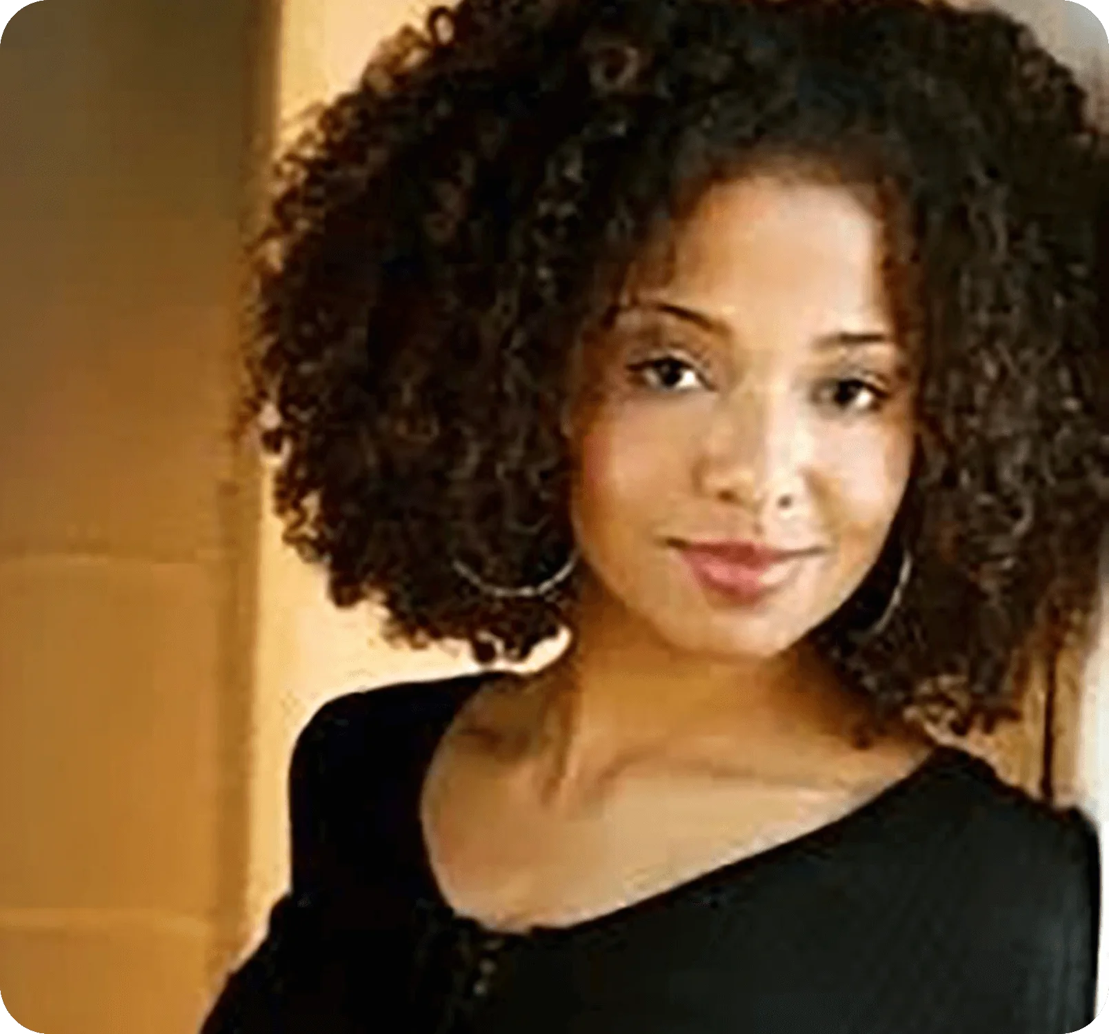 Warm indoor headshot of a woman with curly hair in Clemmons, NC – Birch Stream Digital